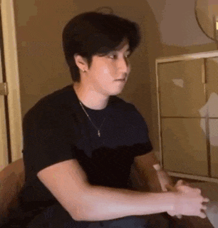 a man is sitting in a chair with his hands folded in front of him .