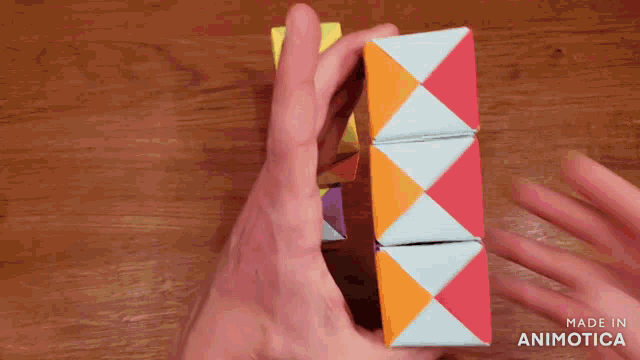 a person is holding a colorful cube that is made in animotica
