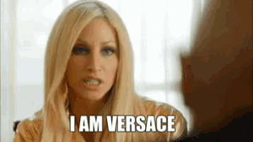 a woman with blonde hair is talking to a man and saying `` i am versace '' .