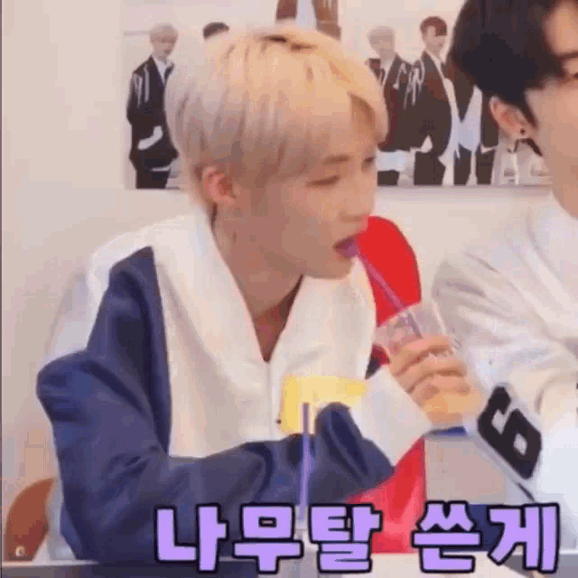 a man is drinking from a plastic bottle through a straw .
