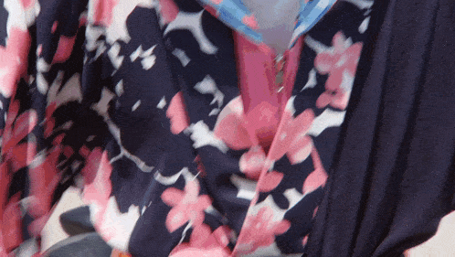 a close up of a pink and blue floral shirt with a zipper