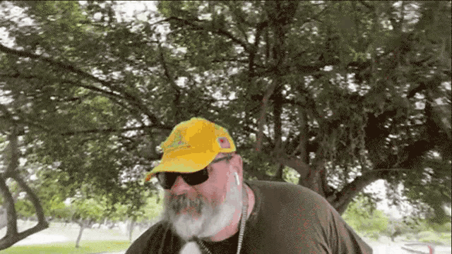 a man wearing a yellow adidas hat and sunglasses