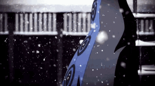 a person is standing in the snow wearing a blue and black umbrella .