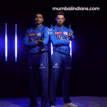 two men are posing for a picture with mumbaiindians.com in the corner