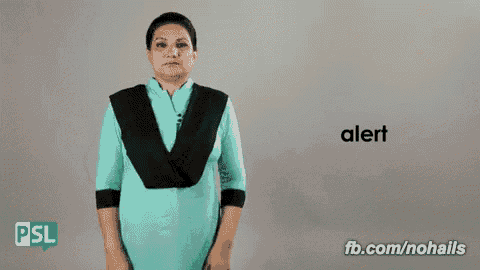 a woman in a blue dress says alert in a sign language video