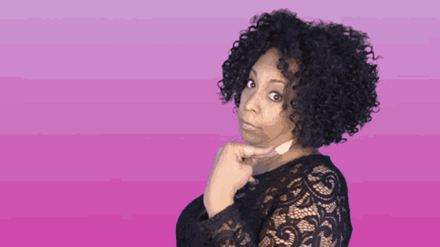 a woman with curly hair is wearing a black lace dress