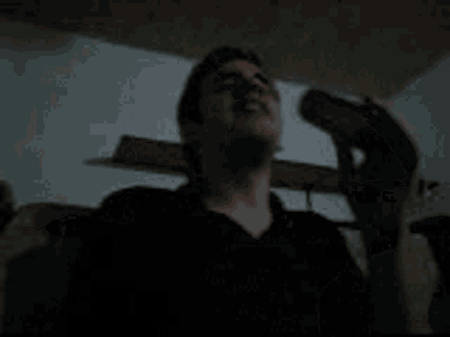 a blurry picture of a person standing in a dark room with their arm up