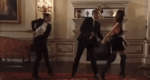 a group of people are dancing together in a living room .