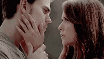 a man and a woman are looking into each other 's eyes and touching each other 's faces .