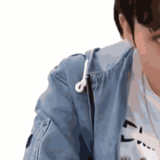 a close up of a person wearing headphones and a blue jacket .