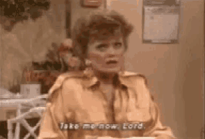 a woman in a yellow shirt is sitting at a table talking to a man .