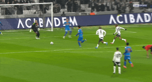 a soccer game is being played in front of a sign that says acibaden