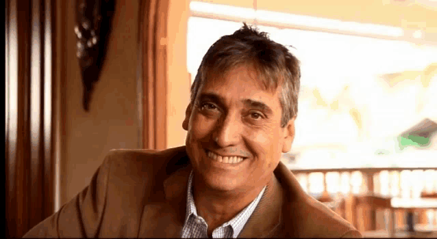 a man in a suit smiles for the camera