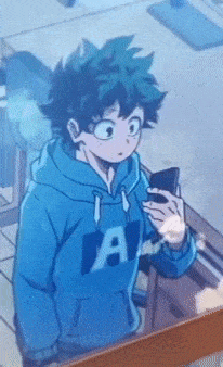 a person in a blue hoodie with the letter a on it is holding a cell phone .