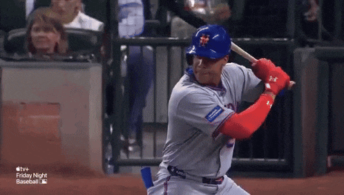 a baseball player is swinging at a pitch during a friday night baseball game ..