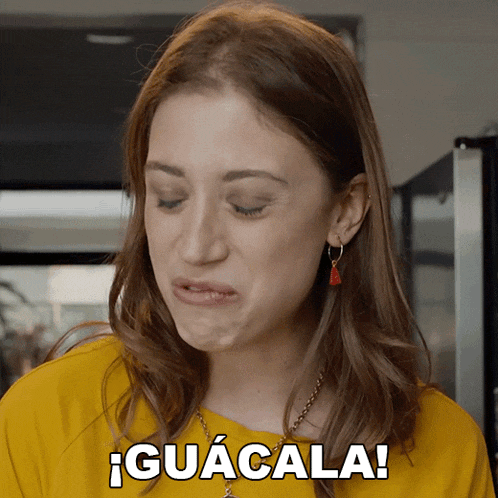 a woman in a yellow shirt is making a funny face and the word guacala is above her