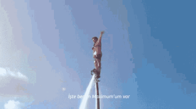 a man is riding a wave in the ocean with the words iste benim maximum ' um var below him