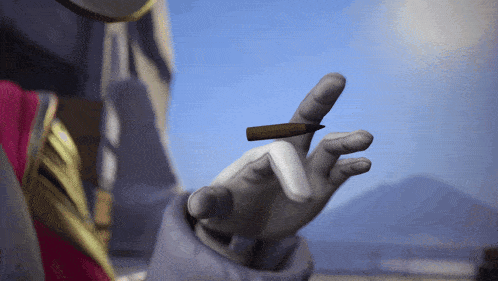 a person is holding a cigarette in their left hand