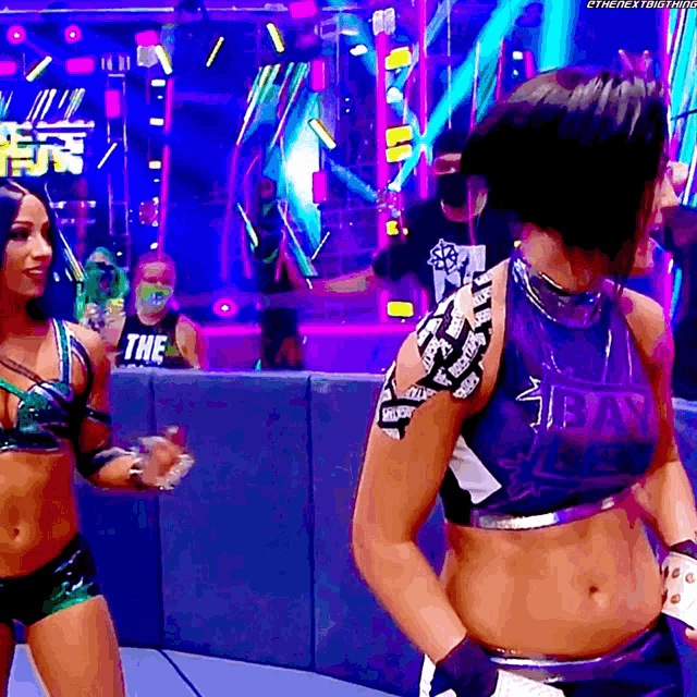 a female wrestler wearing a blue shirt that says bay