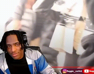 a man wearing headphones is sitting in front of a wall with a picture of a person behind him .