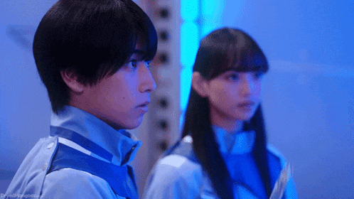 a boy and a girl are standing next to each other in a dark room .