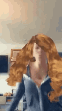 a woman with long red hair is wearing a gray shirt