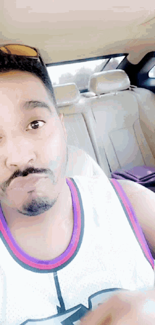 a man with a beard is wearing a white tank top with a purple border
