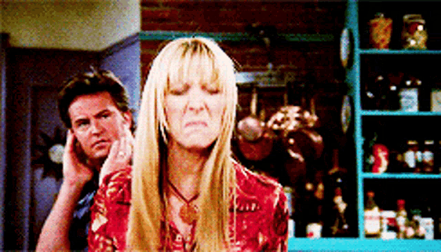 a man and a woman are standing next to each other and the woman is making an angry face