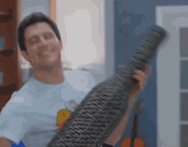 a man in a simpson shirt is holding a large object in his hands
