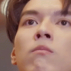 a close up of a man 's face with headphones on looking up at the camera .