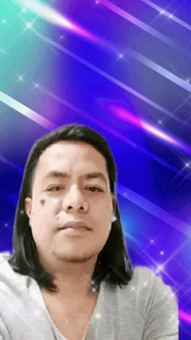 a man with long hair stands in front of a blue background