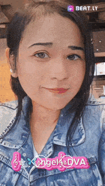 a woman in a denim jacket with angel dva written on her chest