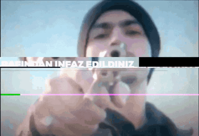 a man is pointing a gun at the camera with the words " barindan infaz edildiniz " written on the bottom