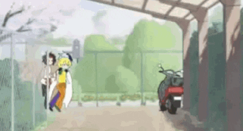 a group of people are walking down a sidewalk next to a fence and a motorcycle .