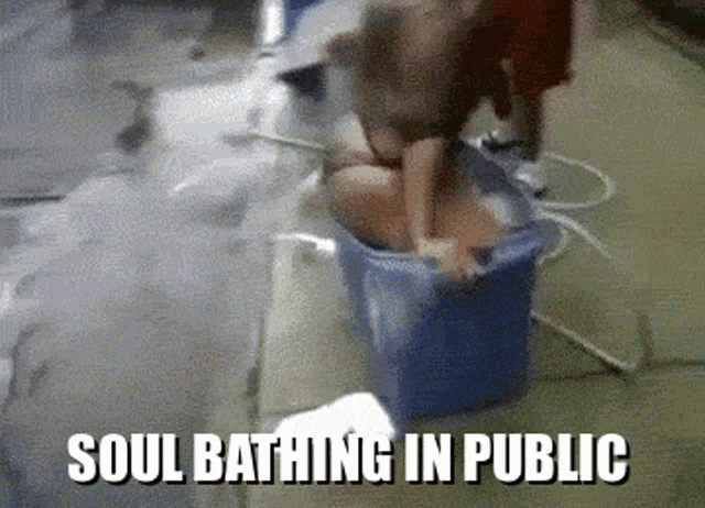a cat is taking a bath in a bucket with the words soul bathing in public