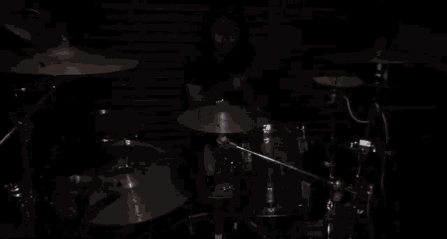 a man playing drums in a dark room with a cymbal that says sabian on it