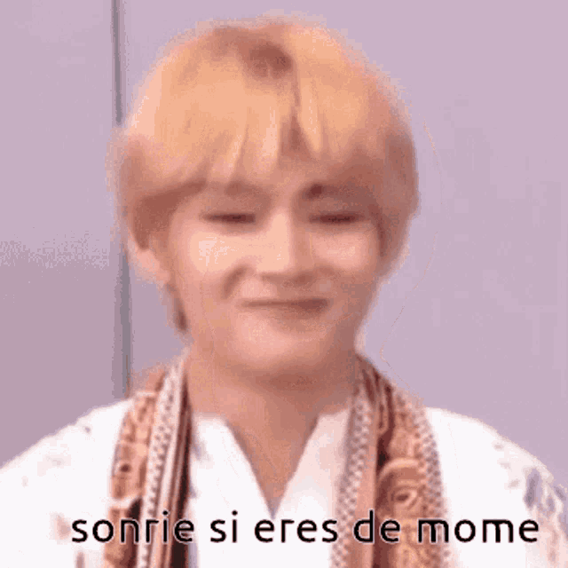 a close up of a person 's face with the words sonrie si eres de mome on it .