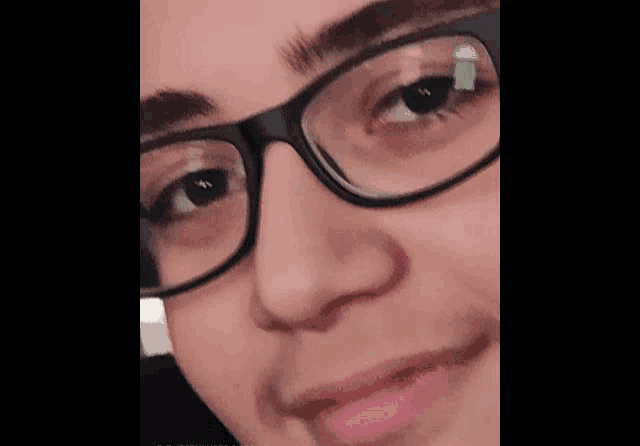a close up of a person wearing glasses and making a face .