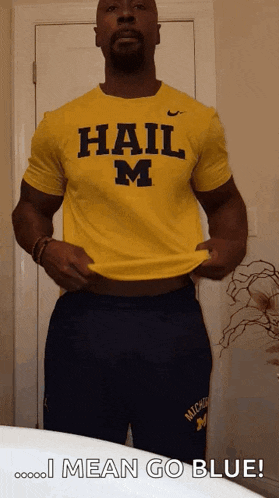 a man is wearing a yellow shirt that says hail m on it