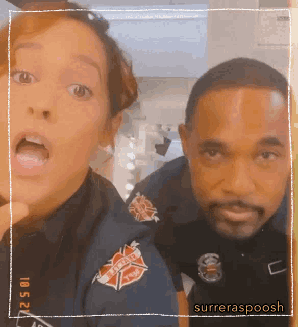 a man and a woman are posing for a picture with a fire department patch on their uniforms