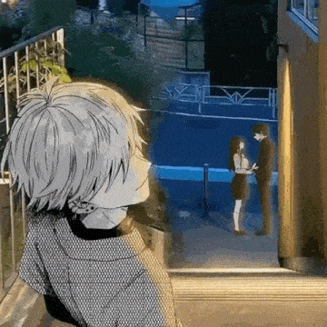 a man and a woman are standing next to each other in front of a window .
