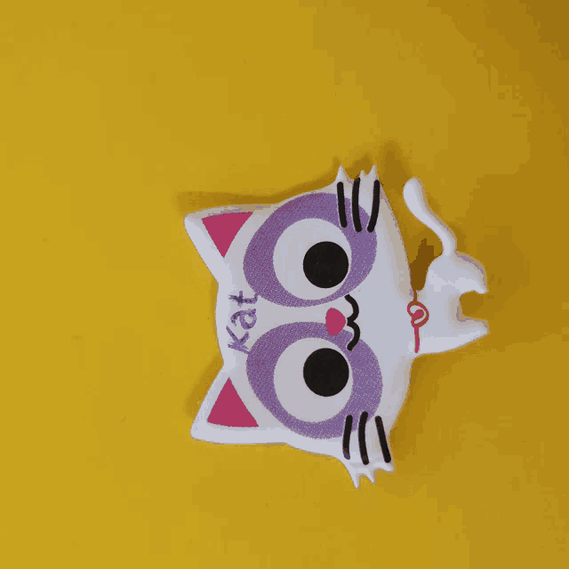 a white cat with purple eyes and kat written on its face