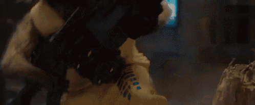 rocket raccoon from guardians of the galaxy is holding a gun in his hand .