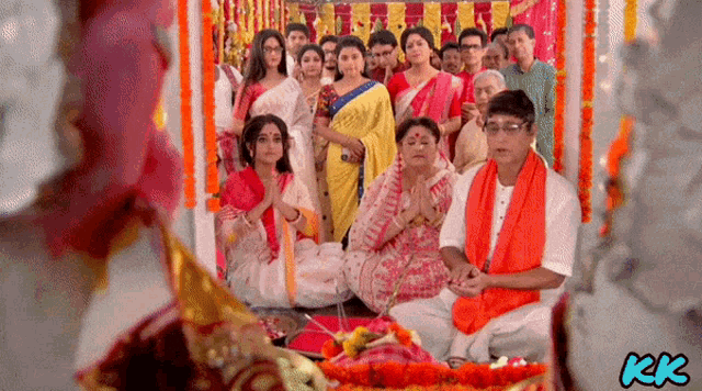 a group of people sitting in a room with kk written on the bottom right