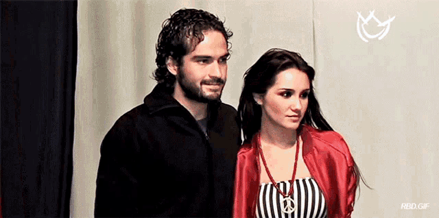 a man and a woman standing next to each other with a rbd gif in the bottom right corner