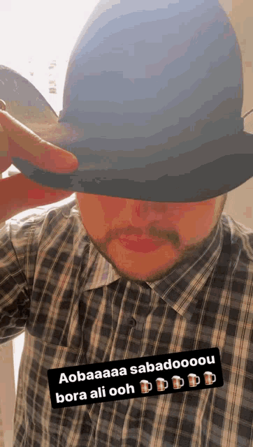 a man wearing a plaid shirt and a blue hat says aobaaaa sabadooou bora ali ooh
