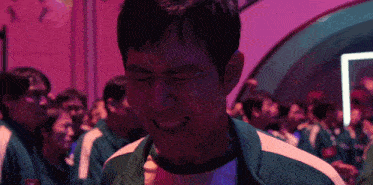 a man wearing a green and white striped shirt is smiling with his eyes closed