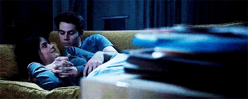 a man and a woman are laying on a couch and hugging each other .