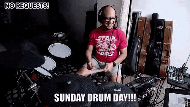 a man in a star wars shirt is playing drums in a room .