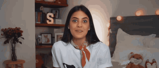 a woman wearing a white t-shirt with the letter s on it